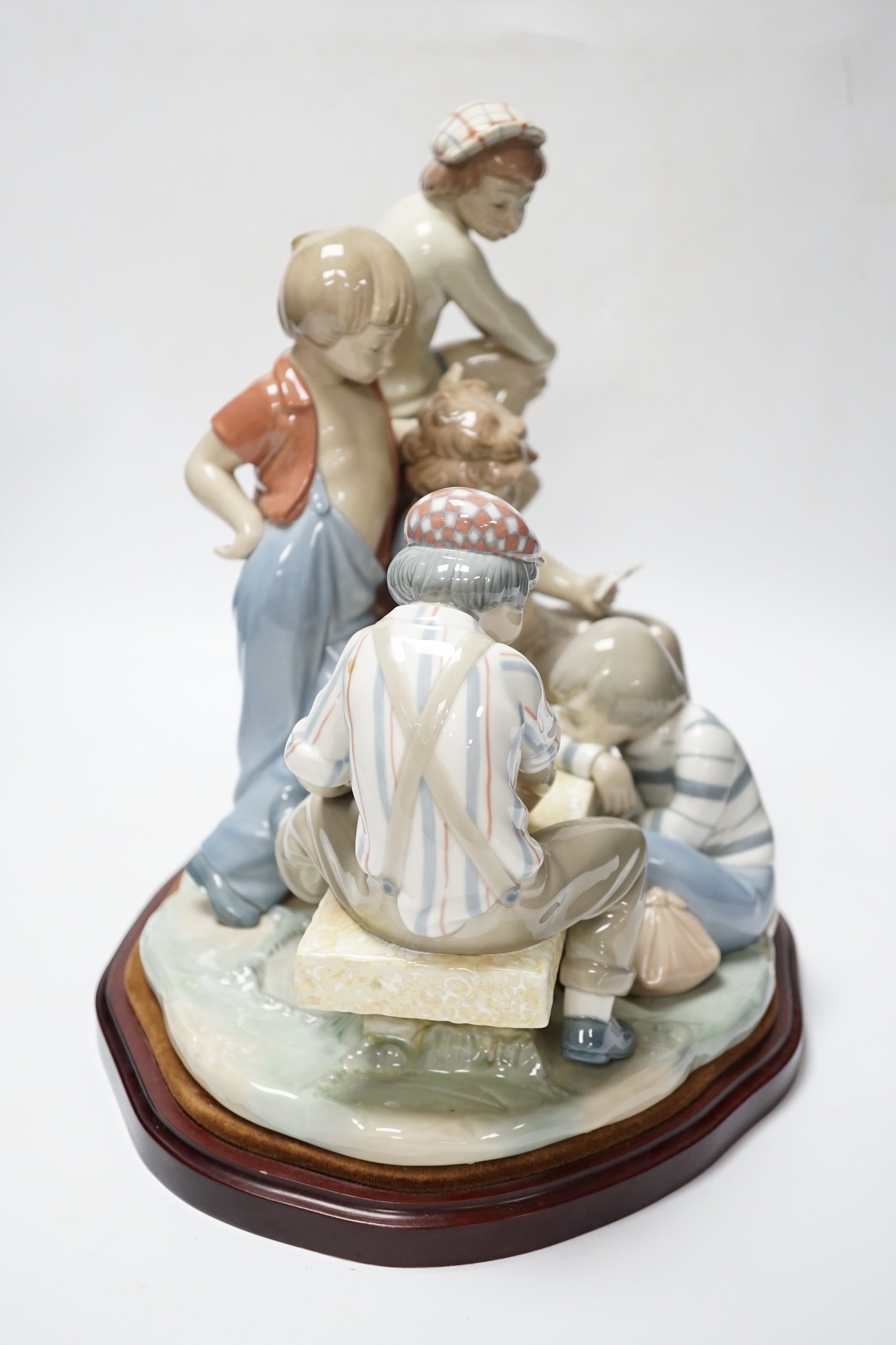 A large Nao figure group on stand of five boys sitting around a table playing cards, 33cm